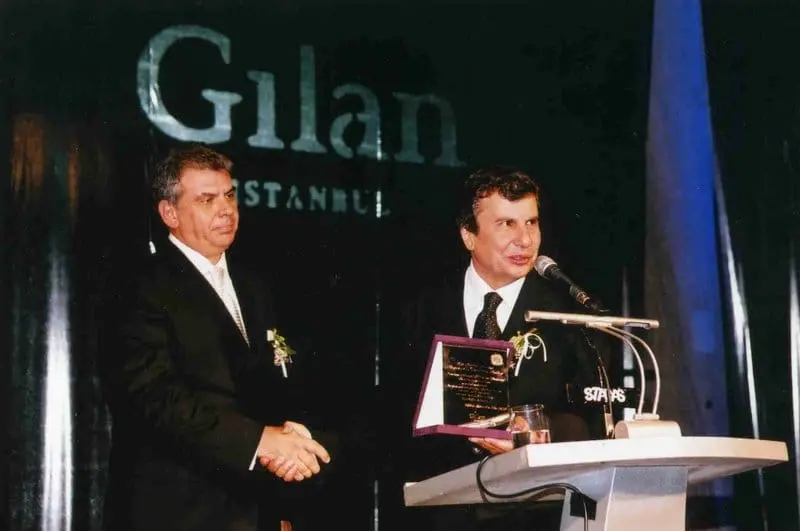 Sahnede “Gilan İstanbul” pankartı önünde plaket takdimi