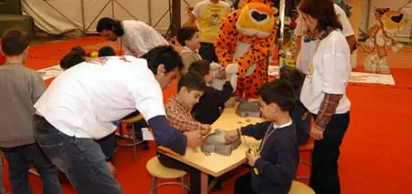 Masalarda turnuvaya katılan çocuklar ve görevliler