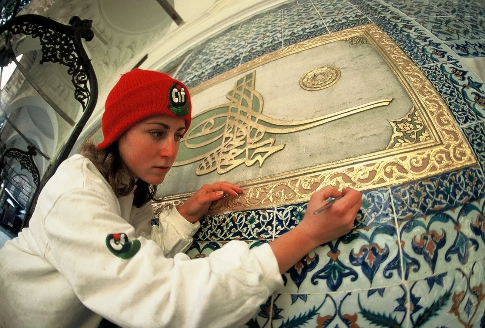 Tuğralı çini panoyu temizleyen restoratör